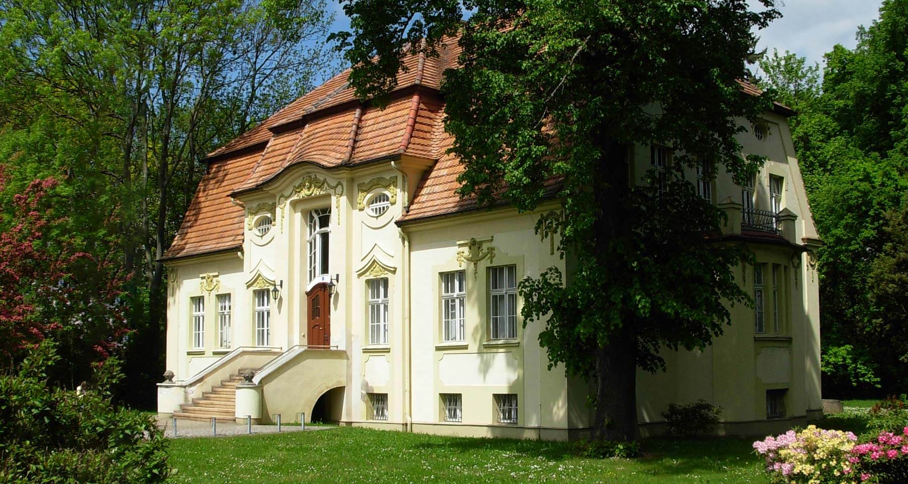 Gemeindeamt Horka - gelbes Gebäude mit rotem Ziegeldach und Stuckelementen