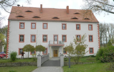 Verwaltungsgebäude Weißer Schöps/Neiße - Weg führt über eine Brücke über einen Wassergraben zum Eingang.